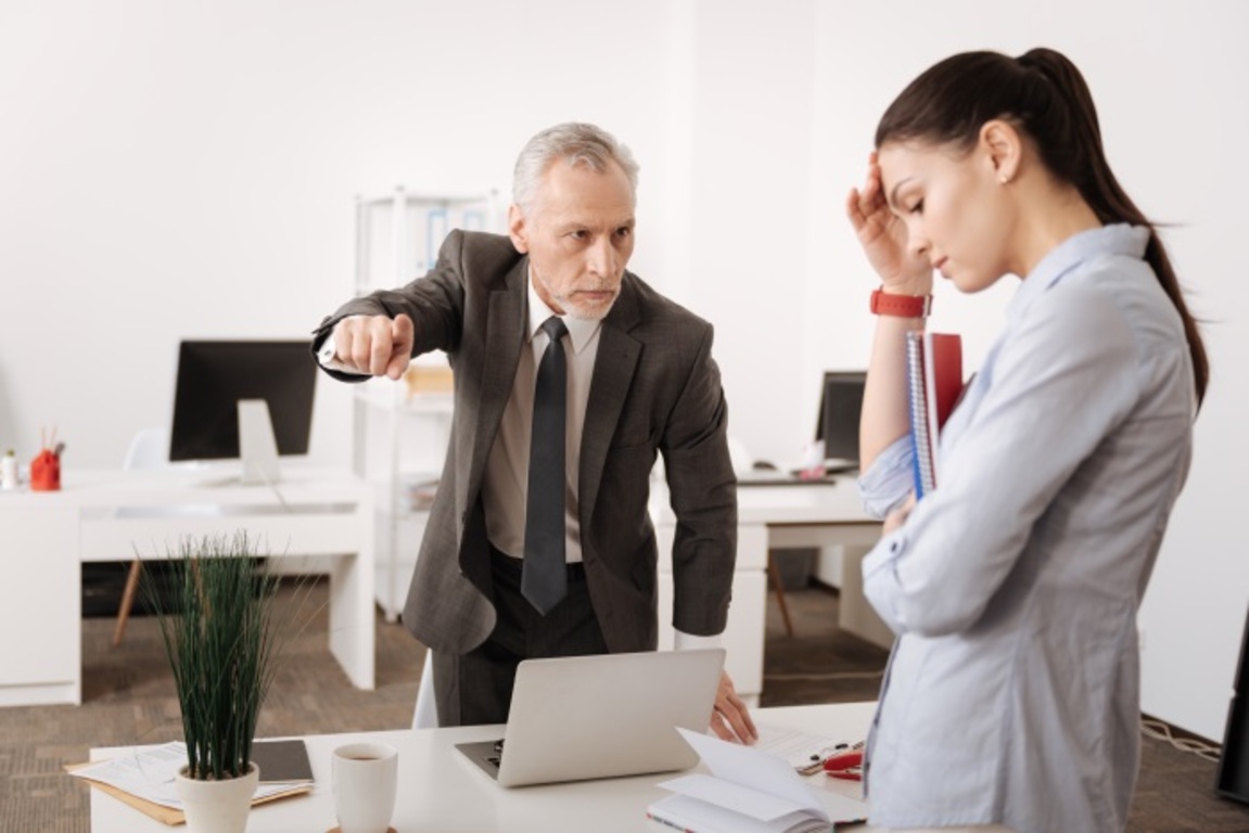 A man can be seen looking aggressively at a woman to represent retaliation against sexual harassment at workplace.